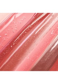 Glossy lip gloss swatches in various shades of pink, featuring a smooth texture with fine sparkles and visible bubbles.