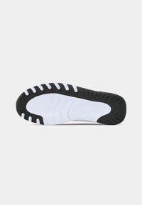 Hvid og sort sportsko sål med en struktureret finish, der har buede riller og et centralt Nike-logo for greb og støtte.