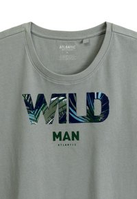 Szara koszulka z krótkimi rękawami, z okrągłym dekoltem, z graficznym wzorem z napisem "WILD" w zielonych i wzorzystych literach, a "MAN" w jednolitym zielonym.