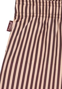 Pruun ja beeži triibuline kangas elastse vöökohaga. sisaldab väikest kootud silti, millel on kirjas "Packies". Sile tekstuur, kerge materjal.