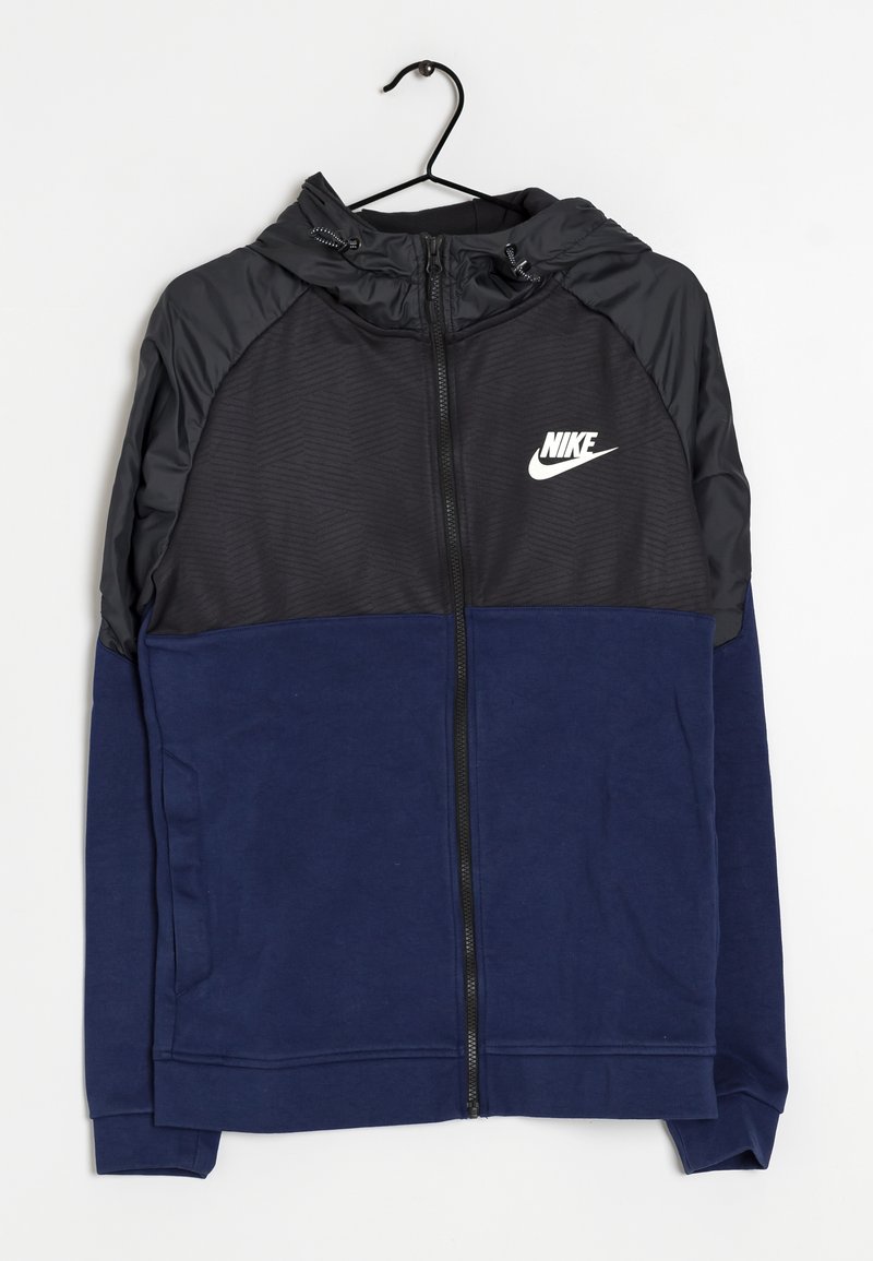 Nike zip-up huppari, jossa on musta yläosa, jossa on teksturoitu kuvio, ja tummansininen alaosa, valmistettu pehmeästä kankaasta ja varustettu nyörihuppupäällä.
