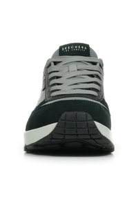 Sneaker neri e grigi con parte superiore in suede e mesh, lacci grigi, accenti grigi, suola intermedia bianca e suola esterna in gomma nera texturizzata.