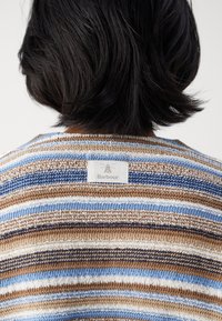 Pull en maille avec des rayures horizontales en bleu, marron et blanc, doté d'une texture tissée et d'une étiquette Barbour à l'arrière du col.