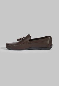 Dunkelbraune Lederloafers mit strukturiertem Obermaterial, dekorativer Naht und einem Quast-Akzent. Flexible Gummisohle und Slipper-Design.