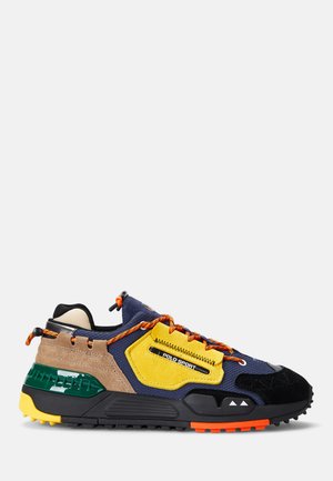 Multicolored sneaker featuring a navy upper, yellow suede accents, orange laces, textured black and green sole, and a rugged design.