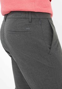 Grijze op maat gemaakte broek met een subtiele textuur, voorzien van een met rits afsluitbare zak aan de achterkant en een enkele paspelzak, gemaakt van een duurzaam materiaal.