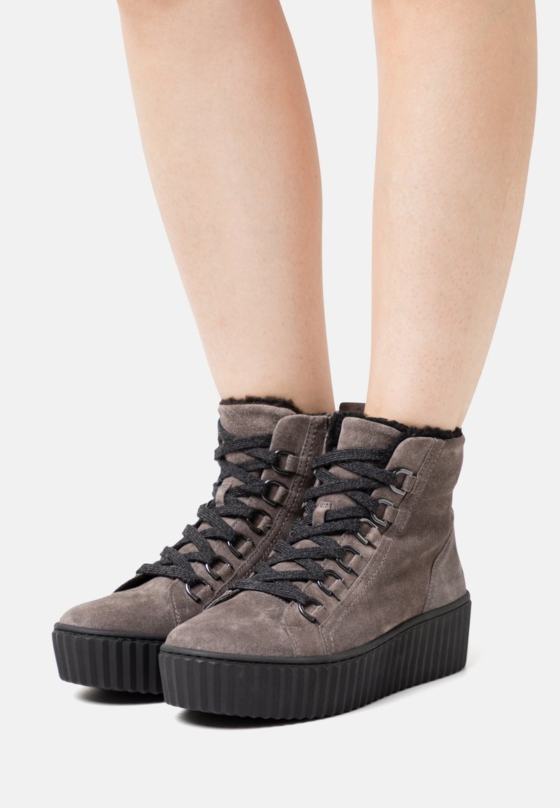 Szare zamszowe sneakersy typu high-top z teksturowaną czarną platformą, z czarnymi sznurówkami i puszystym wykończeniem kołnierza przy otworze.