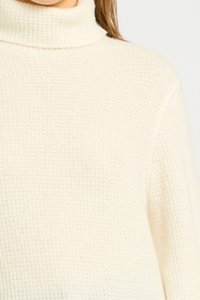 Maglione a collo alto in maglia waffle di colore crema, con una superficie testurizzata e una vestibilità rilassata, realizzato con un materiale morbido e caldo.