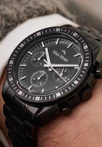 Schwarz-oxidierte Edelstahl-Chronographen-Uhr mit schwarzem strukturiertem Zifferblatt, weißen Stundenmarkierungen und drei kleinen Ziffernblättern. Markennamen auf dem Zifferblatt sichtbar.