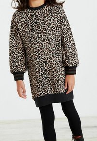 Abito con stampa leopardata a maniche lunghe, con polsini e orlo a coste nere, realizzato in tessuto morbido. Abbinato a leggings neri.