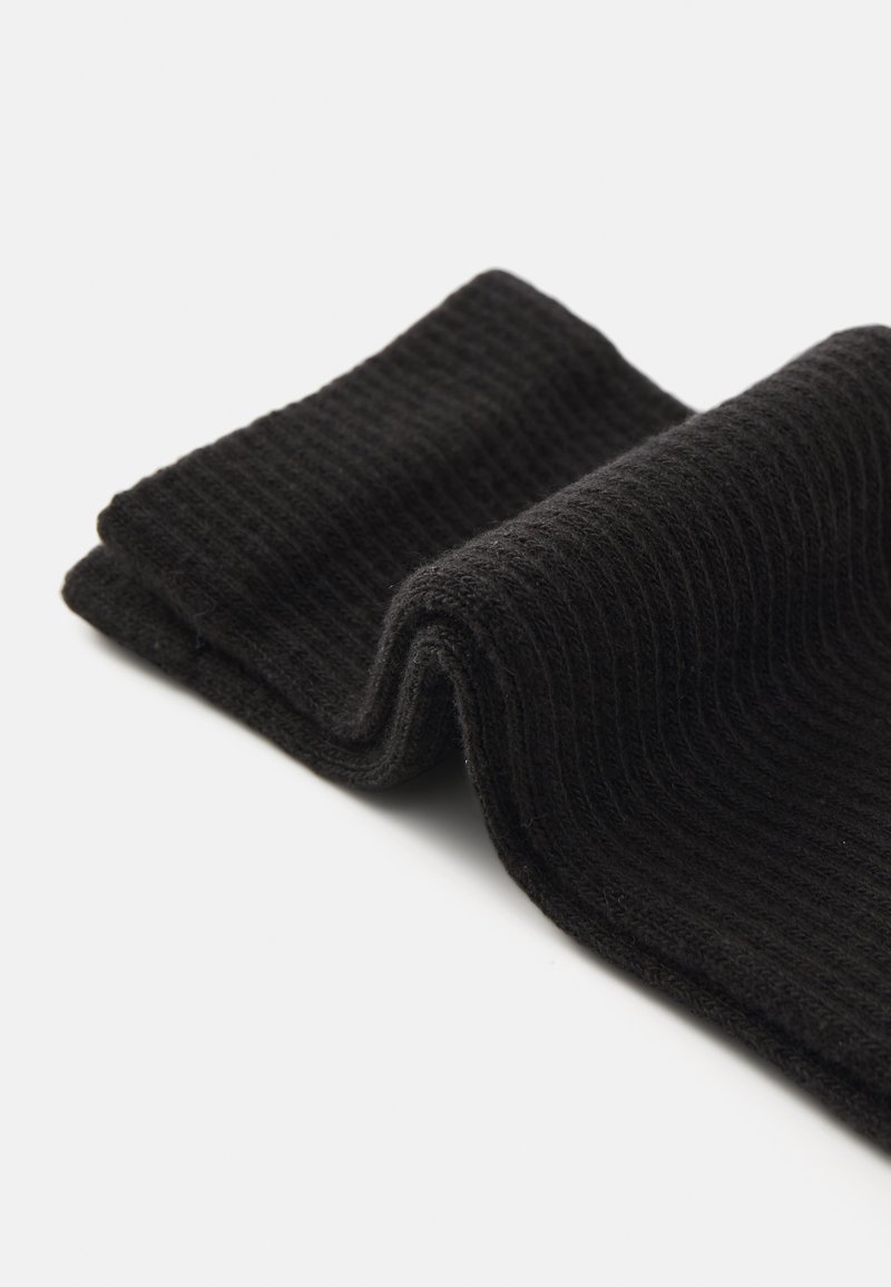 Tissu noir côtelé, plié avec une surface texturée, présentant une apparence douce et confortable avec un contour lisse. Aucune motif ou accent visible.