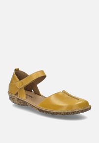Zapatos Mary Jane de cuero amarillo con una correa cruzada, puntera redondeada, suela de goma texturizada y detalles de costura en el material superior.