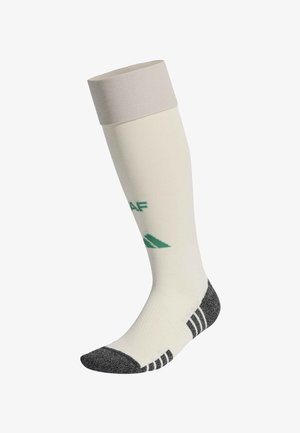 Skarpeta za kolano w białym kolorze z szarym palcem i piętą, czarnymi paskami na podeszwie oraz zielonym logo na części łydki.