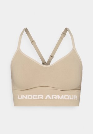 Béžová sportovní podprsenka s nastavitelnými překříženými ramínky a hladkým povrchem. Na pásku je bílá logo "UNDER ARMOUR".