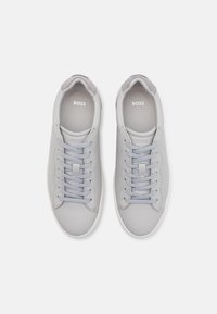 Jasnoszare skórzane sneakersy z szarymi akcentami, zaokrąglonym noskiem i sześcioma oczkami do sznurowania. Posiadają miękką wewnętrzną wyściółkę i subtelne oznakowanie.