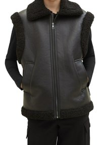 Schwarze Lederweste mit strukturiertem schwarzem Kunstpelzkragen und -kanten. Verfügt über einen Reißverschluss und zwei Seitentaschen.