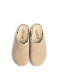 Scarpe slip-on beige realizzate in morbida pelle scamosciata con un rivestimento interno soffice. Presentano una superficie liscia e un design minimalista.