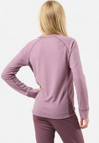 Pitkähihaista puseroa mauve-ribbitaskusta rentoa istuvuutta. Ominaisuuksiin kuuluvat raglan-hihat ja pyöristetty helma. Yhdistetty vastaaviin housuihin.