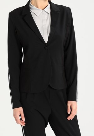 Schwarzer maßgeschneiderter Blazer mit einem Knopfverschluss, scharfem Kragen und zwei Seitentaschen. Besitzt kontrastierende weiße Streifen an den Ärmeln.