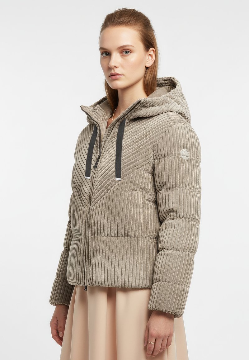 Beżowa pikowana kurtka z kapturem, z pionowymi i chevronowymi prążkowanymi wzorami, czarnym zamkiem błyskawicznym i sznurkiem do regulacji, miękka w dotyku i dopasowana w kroju.