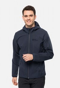 Veste softshell bleu marine avec une fermeture éclair à l'avant, une capuche réglable et deux poches latérales. Arbore le logo Jack Wolfskin sur la poitrine.