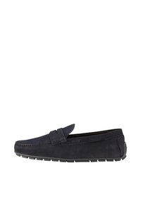 Mocasin de ante azul marino con detalles de costura, diseño sin cordones y suela de goma. Presenta un tacón plano y un logo minimalista en el lateral.