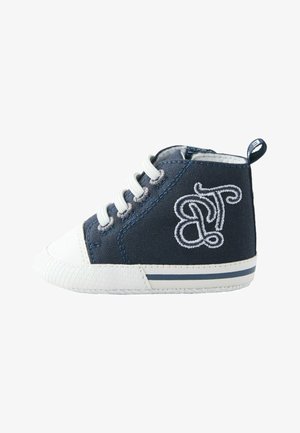 Zapato de lona azul marino de caña alta con puntera y suela de goma blanca, con cordones blancos y detalles bordados en el lateral.