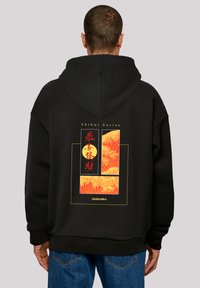 Black hoodie featuring a back graphic with red-orange wave patterns and circular accents. Casual fit, with a drawstring hood.