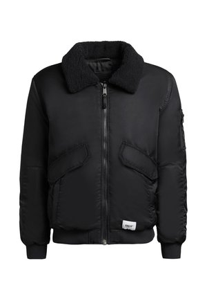 Schwarze Bomberjacke mit flauschigem Halskragen, Reißverschluss und zwei vorderen Taschen. Verfügt über elastische Bündchen und ein kleines Logopatch am Saum.