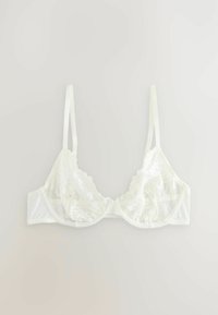 Wit bralette met kantdetail, voorzien van doorzichtige cups en verstelbare bandjes; heeft een sluiting op de rug en een zachte voering voor comfort.