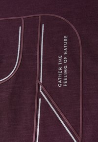 Burgundy-kangas, jossa on teksturoitu pinta, valkoisia ja vaaleanruskeita geometrisia kuvioita sekä painettu teksti, joka sanoo "KERÄÄ LUONNON TUNNE".