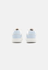 Vita och ljusblå sneakers med en slät läder- och meshöverkonstruktion, vadderad krage och gummisula, med minimalistisk design.