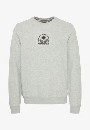 Siva dukserica od mješavine pamuka. Ima okrugli izrez i duge rukave s rebrastim manžetama. U središtu se nalazi crni grafički print.