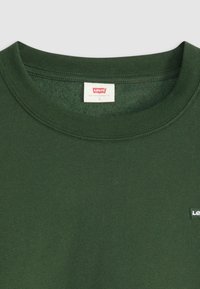 Sweatshirt vert en coton à col rond avec une texture douce, présentant une étiquette rouge Levi's à l'intérieur du col et un petit logo Levi's à l'avant.