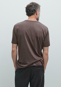 Brun kortærmet t-shirt lavet af blødt stof, med en afslappet pasform og glat tekstur, samt et enkelt, minimalistisk design.