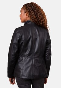 Black leather jacket with a tailored fit, high collar, vertical stitching details, and smooth texture. Features a fitted silhouette and long sleeves.