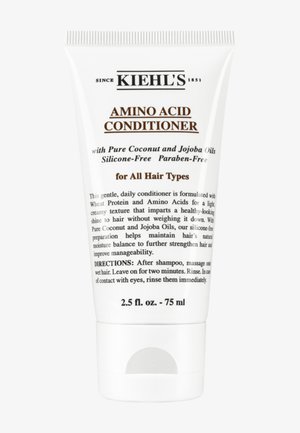 Tubo de plástico blanco con tapa plateada, con texto en negro y marrón. Producto etiquetado como "Acondicionador de Aminoácidos" para todo tipo de cabello.