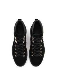 Juodų zomšinių žygių batų su sidabro metalinėmis detalėmis, kuriuose yra keli nėrimo kabliukai, apvalus pirštas ir paminkštinta apykaklė, užtikrinanti atramą.