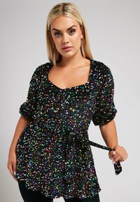 Blusa negra con lentejuelas y adornos multicolores, escote cuadrado, mangas cortas y un cinturón atado en la cintura. Textura brillante en toda la prenda.