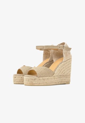 Sandali beige con zeppa intrecciata, cinturini alla caviglia, punta aperta e tacchi platform in juta intrecciata.