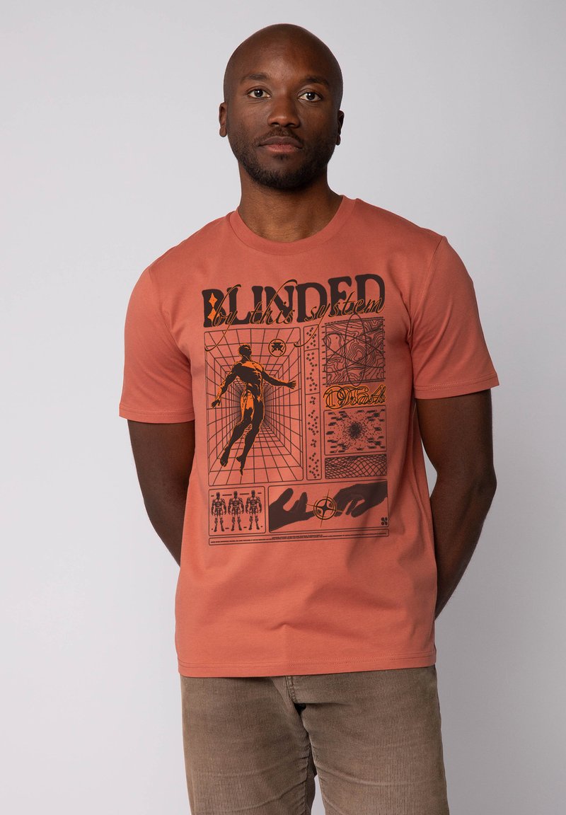 Kortek mouw oranje t-shirt van katoen. Bevat een gedurfde grafische afdruk in zwart met menselijke figuren en abstracte patronen.