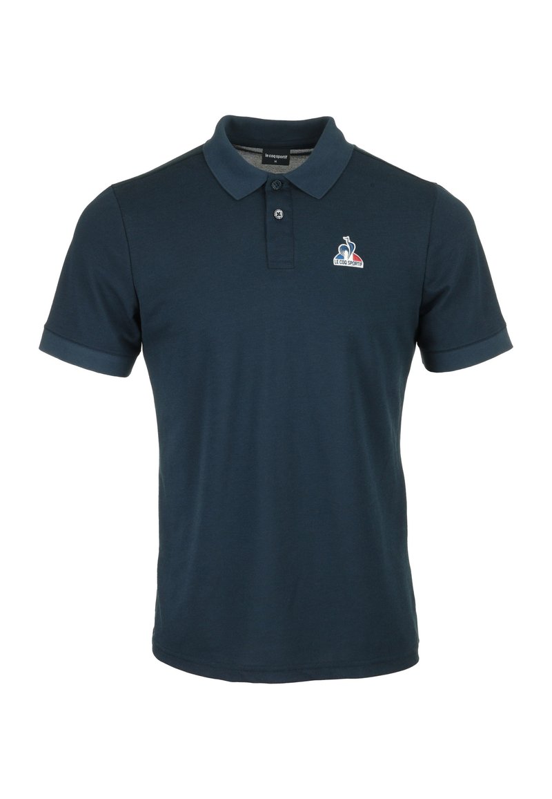 Polo navy de algodón, con cuello clásico, mangas cortas y un logotipo bordado en el pecho. Textura suave.