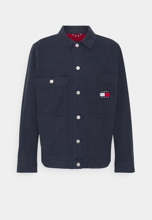 Marineblaue Jeansjacke mit Knopfverschluss, zwei Brusttaschen und einem Logopatch auf der linken Tasche. Verfügt über silberne Druckknöpfe und einen Kragen.