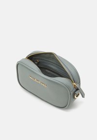 Piccolo astuccio rettangolare grigio in pelle, finitura testurizzata, hardware dorato, chiusura con zip e tirante, logo sul fronte, tasca interna foderata.