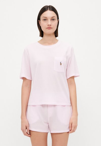 Lys pink bomulds natdragtsæt bestående af en kortærmet t-shirt med en brystlomme og matchende shorts, begge med en afslappet pasform.