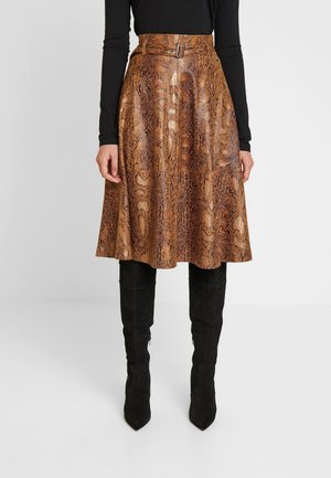 Bruine rok met slangenprint van getextureerd materiaal, voorzien van een hoge taille met een riem en een uitlopende pasvorm, gecombineerd met zwarte kniehoge laarzen.