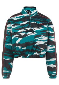 Kortad pulloverjacka med ett mönster i teal och svart kamouflage, halvdragkedja framtill, hög krage och elastisk nederkant med röda detaljer.