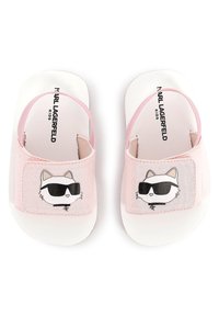 Claquettes roses pour enfants avec semelle blanche, brides élastiques et motif d'un chat portant des lunettes de soleil sur un panneau en tissu rose.