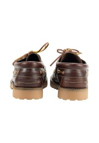 Zapatos de barco de cuero marrón con punta redonda, suela de goma beige y cordones decorativos. Presenta detalles en oro y costuras.