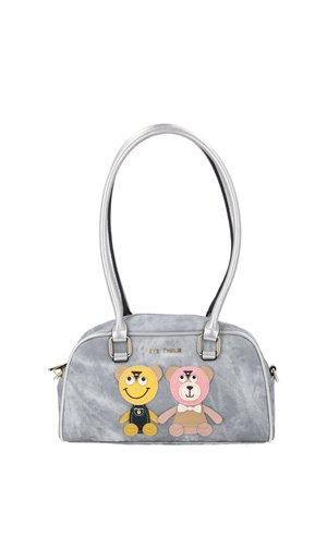 Graue Handtasche mit zwei Teddybär-Aufnähern, einem gelben lächelnden mit Latzhose und einem rosa mit Fliege, und silbernen Doppelgriffen.